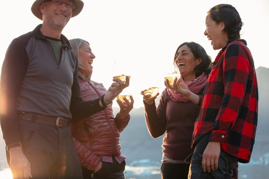 a group of people laughing and holding cups