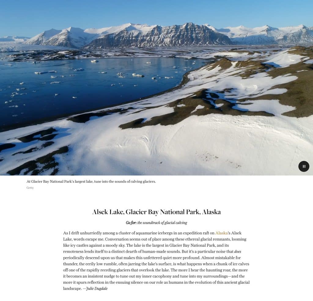 a snowy landscape with a body of water and mountains